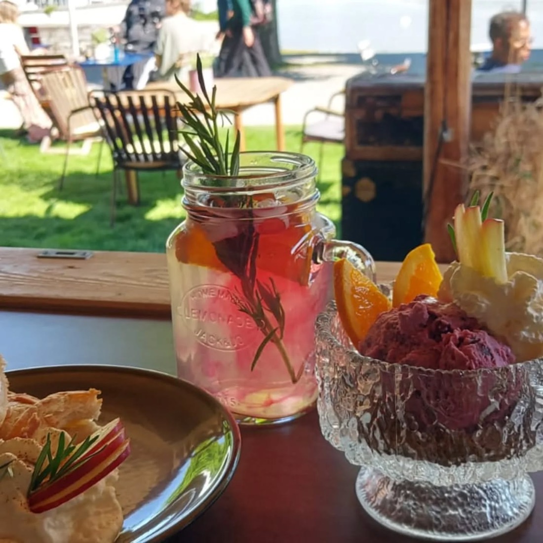 Hausgemachte Beeren-Glace, Limonade mit Rosmarin und Orange sowie ein Toast auf der Seeterrasse